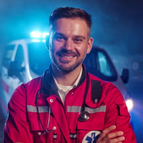 Rettungssanitäter steht vor einem Rettungswagen