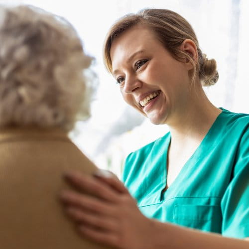 Pflegerin wendet sich einer Patientin zu