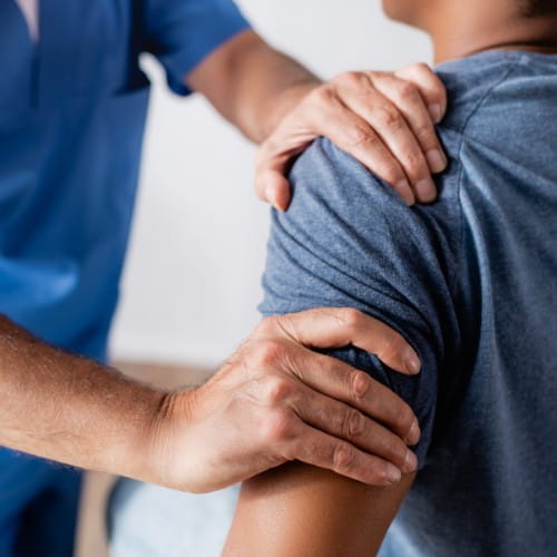 Physiotherapeut behandelt eine Schulter