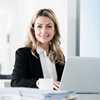 Frau im Business Look am Laptop sitzend